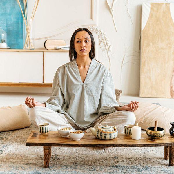 Woman meditating peacefully in a calm, modern setting.